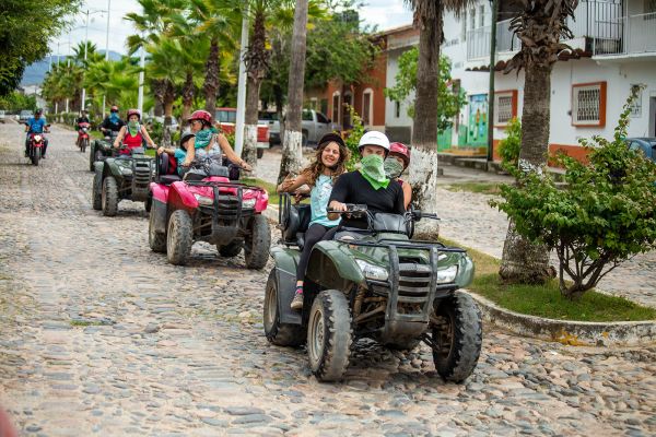 Conductores de ATV con casco saliendo del pueblo de Las Palmas en el tour de cuatrimotos de Rancho Capomo