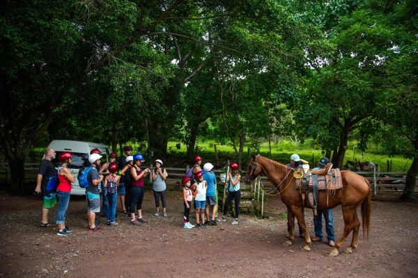Grupo de visitantes con sus caballos en Rancho Capomo antes del tour en caballo