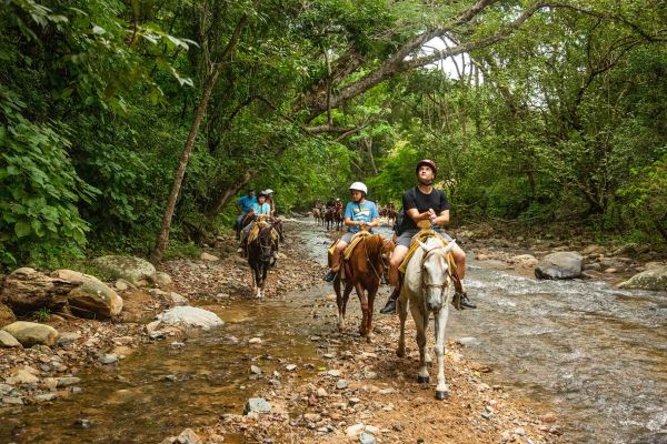 Jinetes siguiendo el sendero del río por la selva cerca de Las Palmas, Puerto Vallarta