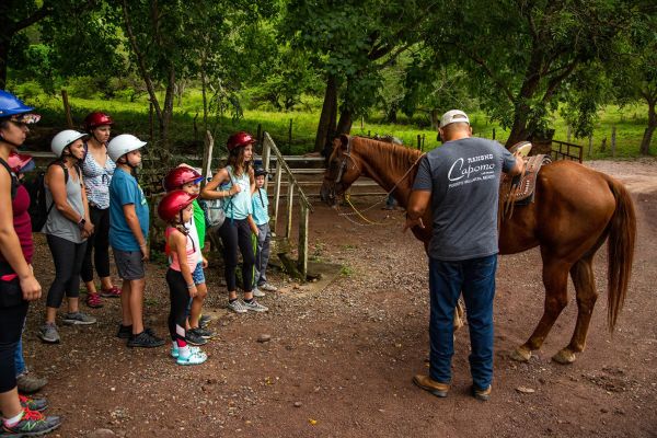 Guía de Rancho Capomo dando la plática de seguridad junto a los caballos antes del tour en caballo