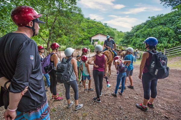 Grupo de visitantes con casco caminando hacia el circuito de tirolesas en Rancho Capomo